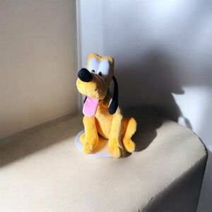 This is a Disney Pluto plush toy, part of the Disney Signature Collection